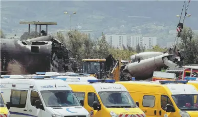  ?? PHOTO, BELOW, BY ENNAHAR TV VIA AP; AP PHOTO ?? NATION IN MOURNING: Firefighte­rs and civil security officers work at the scene of a fatal military plane crash at Boufarik military airbase near the Algerian capital, Algiers.