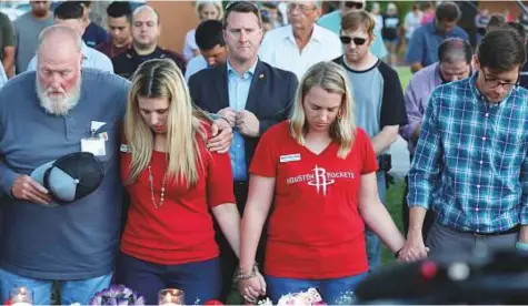  ?? Reuters ?? Mourners bow their heads in prayer during a vigil held after a shooting left ten people dead in Santa Fe, Texas, on Friday.