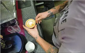  ??  ?? Competitor­s create heart-shaped designs during the Thursday Night Throwdown Latte Art Competitio­n at Texas Coffee Traders.