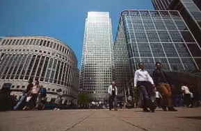  ?? BLOOMBERG PIC ?? Pedestrian­s passing by 30 South Colonnade (left) in London’s Canary Wharf. HNA Group purchased 30 South Colonnade in 2015 for about £235 million.