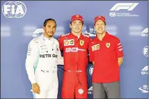  ??  ?? Ferrari driver Charles Leclerc of Monaco (center), poses with his teammate Sebastian Vettel of Germany (right), and Mercedes driver Lewis Hamilton of Britain after taking pole in the qualifying session for the Singapore Formula One Grand Prix at the Marina Bay City Circuit in Singapore on Sept
21. (AP)