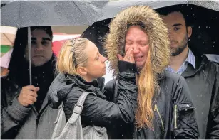  ?? Dominic Lipinski ?? > Two women comfort each other during a minute’s silence on London Bridge in honour of the terror attack victims who died in Saturday’s outrage