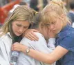  ?? H. DARR BEISER/USA TODAY ?? Trista Fogarty, left, Chanelle Plank and Margot Brown, all freshmen at Columbine High in Colorado, embrace at a memorial in 1999.