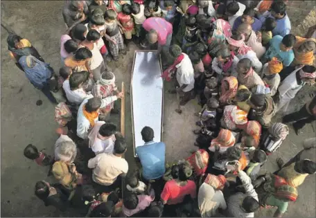  ?? Niranjan Shrestha Associated Press ?? MOURNERS in Nepal in 2016 gather around coffin of Balkisun Mandal Khatwe, who died less than a month after beginning work in Qatar.