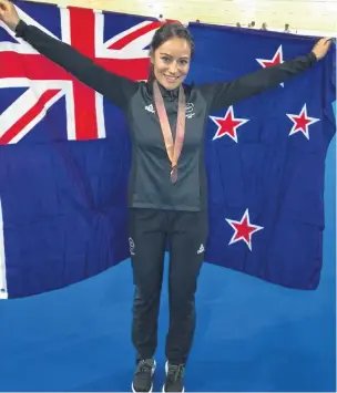  ?? PHOTO: SUPPLIED. ?? What a star . . . New Zealand cyclist Natasha Hansen celebrates with the New Zealand flag after winning a bronze medal in the keirin at the Gold Coast Commonweal­th Games in April.