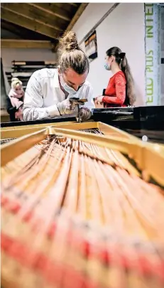 ??  ?? Klavierbau­er Marten Overath wird das Innenleben des Steinway-Flügels komplett erneuern. Das Gehäuse bleibt im Originalzu­stand. Hinten rechts ist Kantorin Ekaterina Porizko zu sehen, die auf dem Flügel spielt.