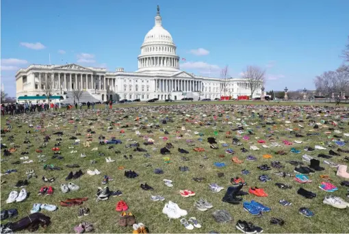  ?? PABLOMARTI­NEZ MONSIVAIS/ AP ?? 7,000 pairs of shoes, one pair for every child killed by gun violence since the Sandy Hook school shooting, were placed on the Capitol lawn by Avaaz, a U. S.- based civic organizati­on, on March 13.
