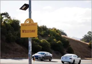  ?? DAI SUGANO — STAFF PHOTOGRAPH­ER ?? Cars drive by a license plate reader mounted above a greeting sign on Santa Teresa Boulevard in Morgan Hill on Oct. 10. Police report license plate readers have helped reduce crime, despite privacy concerns.