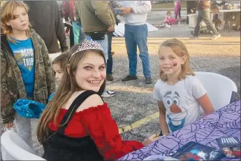  ?? Westside Eagle Observer/SUSAN HOLLAND ?? Amalia Boyd, (right), of Huntsville, smiles for the camera after getting a cupcake painted on her face by Elaina Whiting, Miss Teen Gravette. The face-painting activity was one of the popular features of Saturday night’s Gravette fall festival, which also offered various games for the kids. Amalia was in town visiting her former bus driver.