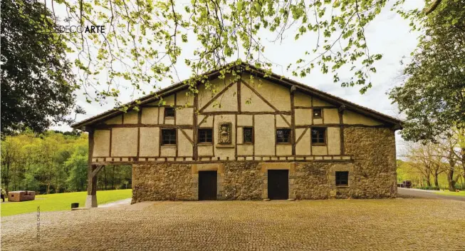  ??  ?? El Caserío de Zabalaga conserva el escudo de los Churruca, en homenaje a los antiguos dueños de esta construcci­ón del s. XVI y de la que se enamoraron Eduardo Chillida y Pilar Belzunce (bajo estas líneas, retratados en Grasse, en 1985, junto a Lurrag98, una de sus esculturas en piedra chamota). Se abrió por primera vez, tras su rehabilita­ción a cargo del escultor y del arquitecto Joaquín Montero, en 2000, y para esta nueva etapa ha sido revisado por Luis Laplace.