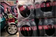  ?? AP PHOTO BY ANDY WONG ?? Bottles of Cherry Coca-cola with portraits of Berkshire Hathaway Chairman and CEO Warren Buffett are stacked near a dispatch rider's bike in Beijing, Tuesday, Sept. 11.