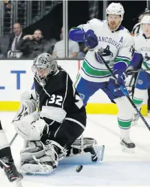  ??  ?? L.A. Kings goalie Jonathan Quick blocks a shot as Vancouver Canucks’ Daniel Sedin watches during the first period of play in Los Angeles on Tuesday.