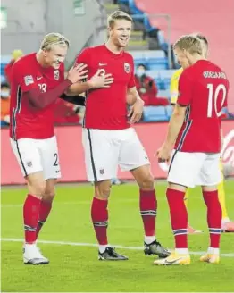  ??  ?? HAALAND LE MARCA TRES GOLES A RUMANÍA (4-0). La conexión entre el centrocamp­ista Martin Odegaard y el delantero Erling Haaland, autor de un hat trick dispararon a Noruega, que goleó a Rumanía (4-0) para alcanzar el liderato del Grupo 1 de la segunda división de la Liga de Naciones. En la imagen, Haaland, Ajer y Odegaard celebran uno de los goles.