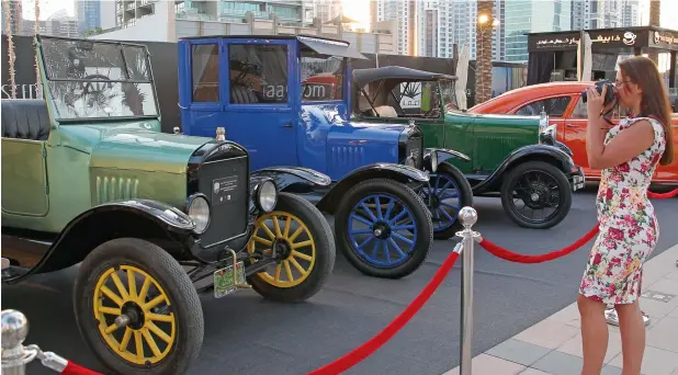  ??  ?? VINTAGE COLOURS … Dubai visitor Admira Hodzic from Sweden takes pictures of Ford Model T classic cars. First introduced in 1908, the Model T is generally regarded as the first affordable automobile that opened travel to middle-class Americans.