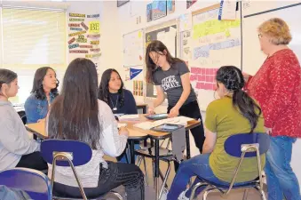  ?? GLEN ROSALES/FOR THE JOURNAL ?? AVID coordinato­r Marjorie Milburn, right, helps Truman Middle School students Cheyenne Elwell, Osiris Rodriguez, Jasmine Garcia, Alandra Rodriguez, Mia Madrid and Vanessa Romero set up a tutorial.