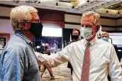  ?? Butch Dill / Associated Press ?? Former Auburn football coach Tommy Tuberville, right, attends a watch party Tuesday. He’ll face Democratic Sen. Doug Jones in the general election.