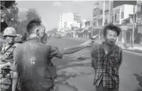  ??  ?? South Vietnamese Gen. Nguyen Ngoc Loan, chief of the national police, shoots a Viet Cong officer in the streets of Saigon on Feb. 1, 1968. EDDIE ADAMS/AP