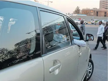  ?? /Moeletsi Mabe/The Times ?? Street wars: An Uber driver in Sandton picks up passengers where he cannot be spotted by a metered taxi driver, after tension developed between the two groups around the Gautrain station in 2015.