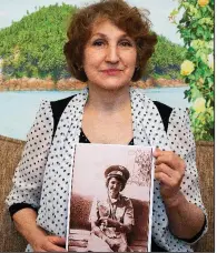  ?? AP/ALEXANDER ZEMLIANICH­ENKO ?? Tatyana Rybalchenk­o shows a photo from her days as a wartime nurse in Afghanista­n.