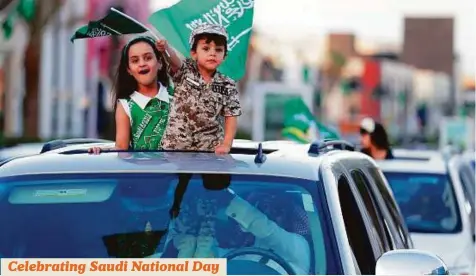  ?? Reuters ?? Saudi children riding in a car celebrate Saudi National Day on a street in Riyadh yesterday.