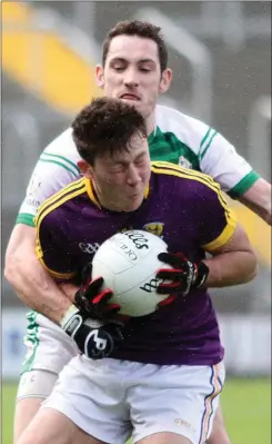  ??  ?? Wexford defender Eoghan Nolan grimaces after this strong tackle.