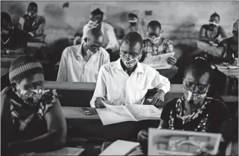  ?? [CHARLES ATIKI LOMODONG/ THE ASSOCIATED PRESS] ?? A trainee reads a handbook on coronaviru­s prevention, at a training session for community health workers conducted by the national NGO “Health Link,” Tuesday in Gumbo, on the outskirts of Juba, South Sudan.