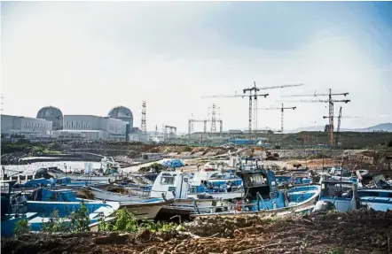  ??  ?? Stopped in its tracks: The Shin Kori No. 3 and 4 nuclear power reactors (left) standing next to the constructi­on site for the No. 5 and 6 reactors in Ulju, Ulsan province. — Bloomberg