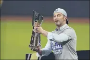  ?? TONY GUTIERREZ — THE ASSOCIATED PRESS ?? Dodgers President of Baseball Operations Andrew Friedman celebrates with the trophy after winning Game 7 of the NLCS against the Braves on Oct. 18.