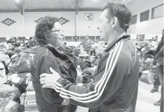  ?? Colleen De Neve/calgary Herald/files ?? Toni Good Eagle, left, accepted a donation from Theo Fleury in June at the Siksika reserve evacuation centre.