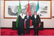  ?? LUO XIAOGUANG/XINHUA VIA AP ?? In this photo released by Xinhua News Agency, Ali Shamkhani, the secretary of Iran’s Supreme National Security Council, at right, shakes hands with Saudi national security adviser Musaad bin Mohammed alAiban, at left, as Wang Yi, China’s most senior diplomat, looks on Saturday during a closed meeting held in Beijing.