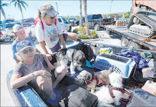  ?? Steve Helber
The Associated Press ?? Steve Gibson helps Maria Zoltac into the back of his truck Saturday with her sister, Susan Zoltac, after being rescued from Sanibel Island in Fort Myers, Fla. More than 1,000 people had been rescued from areas along Florida’s southweste­rn coast.