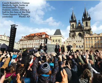  ??  ?? Czech Republic’s Tomas Berdych, right, looks at Switzerlan­d’s Roger Federer, centre, hitting a ball to his fans at the Old Town Square in Prague, yesterday Photo: AP