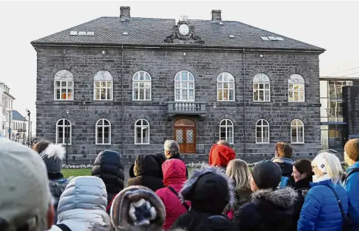  ??  ?? Seeking equality: A group of people looking at Iceland’s parliament in Reykjavik. Icelandic companies must comply with a new law requiring them to prove their pay practices don’t discrimina­te against women. — AP