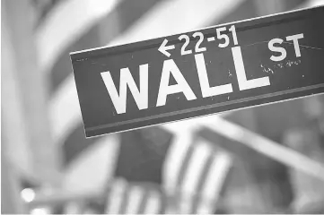  ??  ?? A Wall Street sign is displayed in front of the New York Stock Exchange (NYSE) in New York, on Nov 11, 2016. — WP-Bloomberg photo