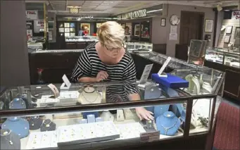  ?? Darrell Sapp/Post-Gazette ?? Sharon McKillop of Freeport arranges jewelry in a case at Goldstock Diamonds &amp; Fine Jewelry in the Clark Building, Downtown. She has been with Goldstock for 20 years.