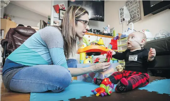  ?? PHOTOS: JOHN MAHONEY ?? Marylène Fortin plays with her son Jaxon at their home in Saint-Eustache, north of Montreal. Jaxon, who is eight months old, has a condition that causes severe breathing pauses. An operation at Sainte-Justine Hospital failed to help him so his parents...