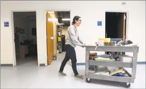  ?? Matthew Brown / Hearst Connecticu­t Media ?? Michele Migliaccio, a long-term substitute art teacher at Newfield Elementary rolls her cart to a classroom to teach art on Friday. The school had to vacate six of its portable classrooms in October due to issues with mold. These classrooms are not set to be replaced, resulting in the crowding of a classroom into makeshift spaces in the main building.