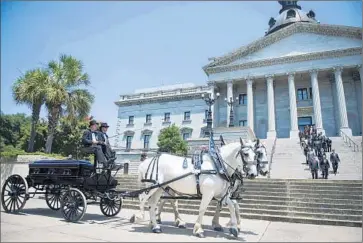  ?? Ji m Watson
AFP/ Getty I mages ?? A CARRIAGE transports the casket of state senator and pastor Clementa Pinckney to South Carolina’s Capitol. There will be two more viewings of Pinckney’s body prior to Friday’s public funeral in Charleston.