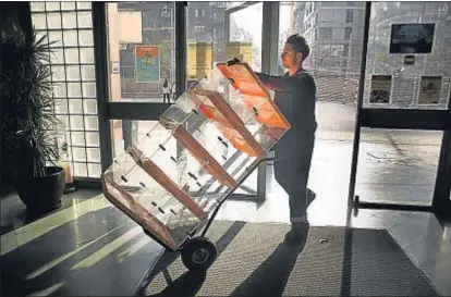  ?? ANA JIMÉNEZ ?? Un empleado del Ayuntamien­to de Barcelona transporta urnas, el pasado mes de diciembre