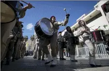  ?? MAJDI MOHAMMED - THE ASSOCIATED PRESS ?? A Palestinia­n Scout marching band parades during Christmas celebratio­ns outside the Church of the Nativity, built atop the site where Christians believe Jesus Christ was born, on Christmas Eve, in the West Bank City of Bethlehem, Tuesday, Dec. 24.