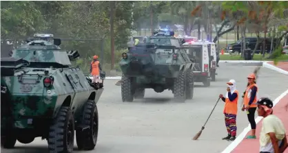  ??  ?? MANILA: Street sweepers watch as a convoy of APCs (Armored Personnel Carrier) and Philippine National Police Special Action Force prepare to conduct a raid to simulate an attack as part of heightened security efforts leading up to next week’s APEC...