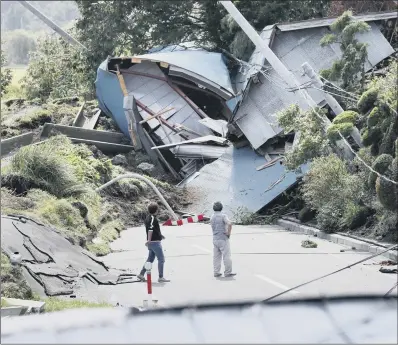  ??  ?? Buildings destroyed by a landslide block a road after the earthquake in Atsuma town, Hokkaido, Japan.