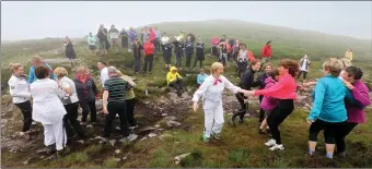  ?? Photo by Valerie O’Sullivan ?? Just the mountain was dampened by the rain.. but the spirits were lifted as walkers trekked up Strickeen to perform a set dance with members of Kilgobnet Biddies.