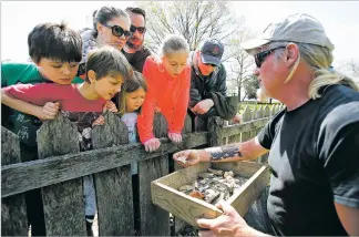  ?? PHOTOS BY STEVE HELBER/ASSOCIATED PRESS ?? A Jamestown Rediscover­y Foundation archaeolog­ist, above, shows artifacts and discusses what’s known about one of the first enslaved Africans to live in English North America in Jamestown, Va. They’re standing at the excavation site, left, of a house where an enslaved woman named Angela lived in the 1600s. A new tour at the site of the historic Jamestown colony encourages visitors to consider the beginnings of American slavery.