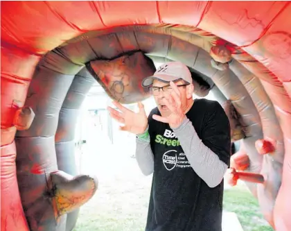  ?? Photo / Duncan Brown ?? Hawke’s Bay District Health Board clinical lead of the bowel screening programme, Dr Guy Vautier, inside a colossal colon at the Hawke’s Bay A&amp;P Show.