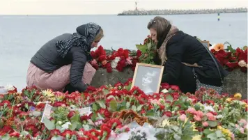  ?? — AFP ?? People lay flowers next to a portrait of one of the victims, famous Russian charity activist and founder of the Voters’ League Elizaveta Glinka or Dr Liza, at a makeshift memorial at the embankment on the shore of the Black Sea in Sochi, on Tuesday.