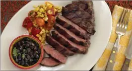  ??  ?? Skirt steak with beer-braised black beans and corn salsa.