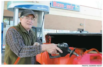  ??  ?? Paul-André Robert a profité de son passage à Gatineau pour remplir une bonne demi-douzaine de bidons d’essence à 0,98 $ le litre.