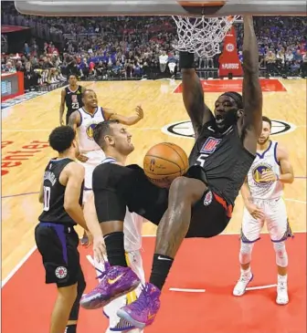 ?? Harry How Getty Images ?? MONTREZL HARRELL SLAMS home a dunk during a loss to Golden State in Game 4 on Sunday afternoon at Staples Center. Harrell’s efficiency on the pick-and-roll has been a key for the Clippers.