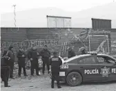  ?? OMAR ORNELAS/DESERT SUN ?? Mexican federal police cordon off a street directly south of border-wall prototypes Monday in a Tijuana neighborho­od, in anticipati­on of President Donald Trump’s visit to the area.